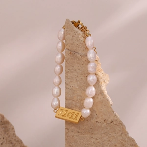 Detail showing freshwater pearls and gold plaque with 11:11 engraving on the bracelet