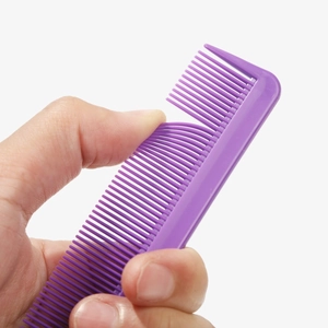 Purple plastic tail comb with flexible steel needle pins shown bending for flexibility