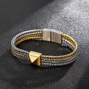 Macro detail of two-tone gold and silver braided steel chain bracelet with magnetic clasp
