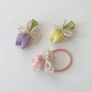 Detail view of handmade tulip hair clips and scrunchie set with pearls and satin fabric