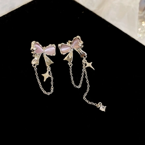 Detail of silver bow tassel earring with pink cat eye stone and star charms