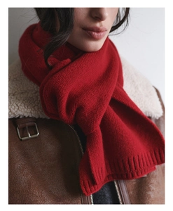 Detail of soft dark red knit wool scarf showing thick texture and ribbed finish