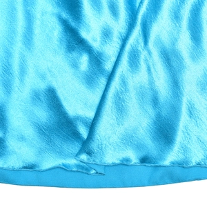 Vue détaillée du tissu en satin bleu montrant la texture de soie et les coutures de l'ourlet