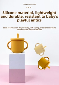 Detailed view of ginger and beige silicone training cups with handles and straws
