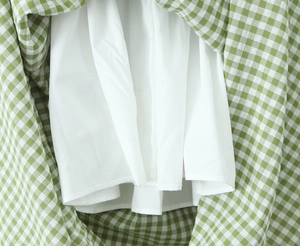 Detail view of the green floral dress featuring white lining and textured fabric stitching