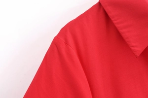 Close-up of red poplin dress neckline showing sharp stitching and cotton fabric detail