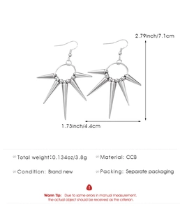 Close-up of silver punk spike drop earrings with five cone pendants on white background