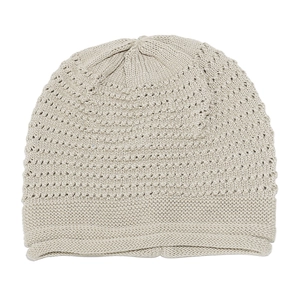 Detail view of beige knitted beanie with intricate hollow pattern and soft ribbed texture
