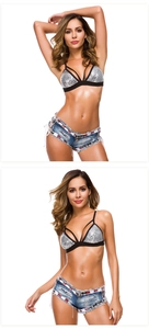 Dettaglio del top con paillettes argento e mini shorts in denim blu con strappi