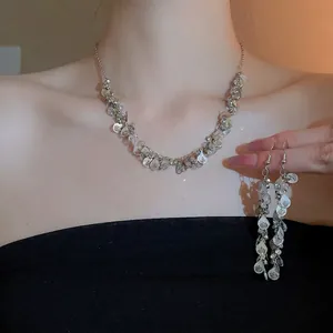 Silver teardrop tassel necklace and earring set with shimmering layered wave pendants