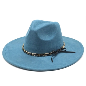 Detail of teal fedora hat featuring a gold chain and black leather bow decoration