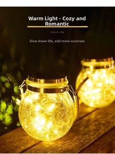 Close-up of solar crackle glass jars with warm yellow LED fairy lights on wood surface