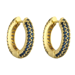 Macro view of gold hoop earrings with three rows of pavé-set deep blue round gemstones