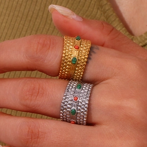 Macro shot of gold and silver textured rings with colorful beads on a model's hand