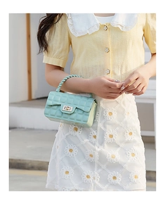 Detail of mint green jelly bag with quilted PVC texture and twist-lock closure