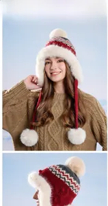 Close-up of Fair Isle knit winter hat with plush faux fur trim and fluffy pom-poms