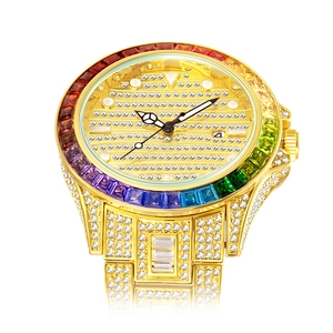 Detail of gold watch featuring rainbow crystal bezel and fully iced out diamond dial