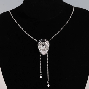 Detail of silver bolo tie necklace with heart pendant and crystals on velvet mannequin