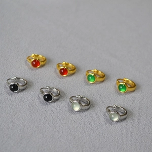 Detail view of gold and silver brass earrings with multi-color agate gemstone inlays