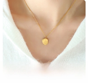 Detail of 18k gold plated titanium steel pendant necklace on a knit sweater