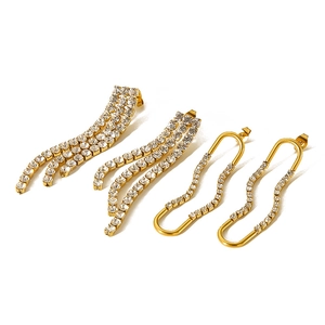 Macro detail of gold-plated tassel and U-shaped earrings with shimmering white zircons