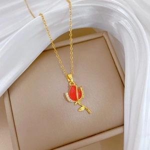Detail of a red rose pendant necklace with diamonds on a beige jewelry box
