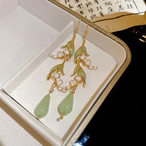 Elegant lily of the valley earrings with green leaf drops and white floral details