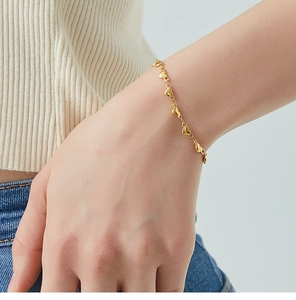Close-up of 18K gold plated bracelet featuring textured heart-shaped chain links on wrist