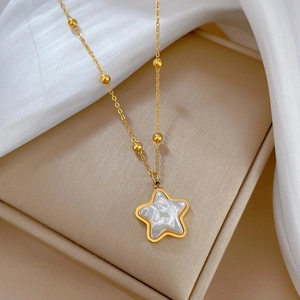 Close-up of a gold star pendant necklace with iridescent shell inlay in a jewelry box