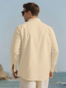 Detail view of the back of a men's linen shirt in apricot beige against a beach background