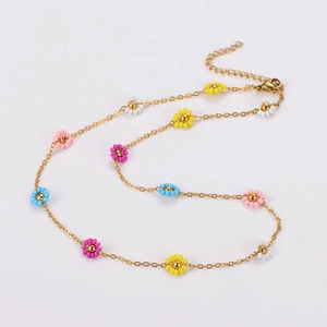 Detail of gold chain necklace with colorful small daisy flower beads and lobster clasp