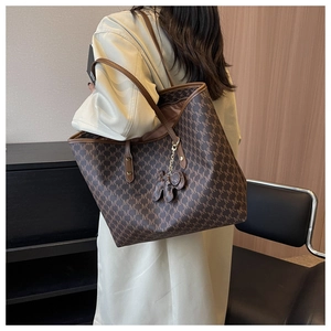 Detalle de bolso tote con monograma, colgante de elefante y gran capacidad real