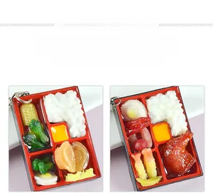 Close-up of miniature food keychains featuring bento lunch boxes with realistic textures