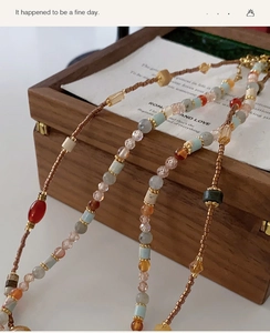 Detailed close-up of retro beaded necklace with colorful stones on wooden jewelry box