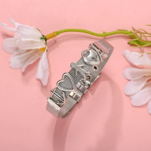 Silver stainless steel mesh bracelet with heart and figure charms on pink floral background