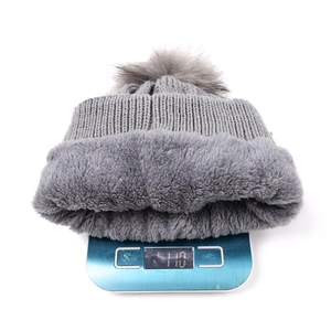 Détail du bonnet en tricot gris montrant la doublure pelucheuse et le poids de 110g