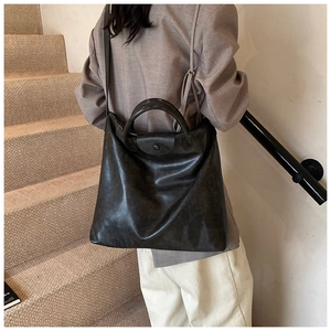 Achteraanzicht van de grote zwarte shopper tas over de schouder in een strak interieur