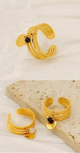 Detail of gold multi-layer adjustable rings featuring round beads and metal charms