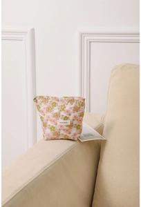 Detail of floral embroidery fabric and metal flower zipper on a large cosmetic bag
