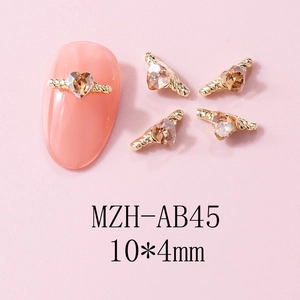 Detailed macro view of champagne heart nail charms with golden twisted metal frame