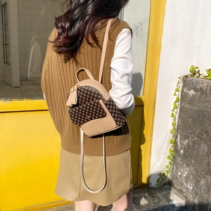 Brown printed leather backpack for women shown on a model in an urban outdoor setting