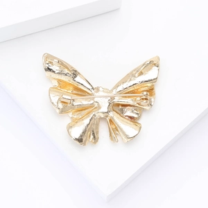 Detailed back view of a golden butterfly enamel brooch showing the secure safety pin clasp