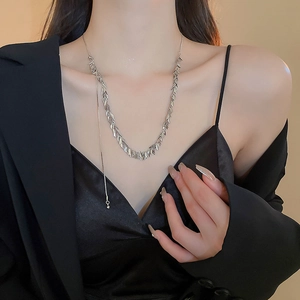 Detail of silver leaf pattern choker necklace with sequins and fringe on model neck