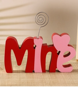 Detailed close-up of a wooden 'Mine' word ornament with a metal spiral photo holder