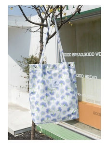 Vista de cerca del bolso tote de pana floral que muestra su patrón vibrante y asas resistentes.