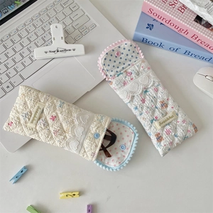 Quilted cotton eyeglasses pouch with lace trim and bear print on white desk