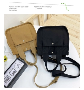 Detail of khaki and black canvas tote bags with front snap pockets on a retro desk