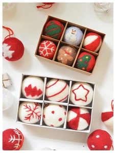 Detail view of handcrafted felt Christmas ball ornaments with snowman and tree embroidery