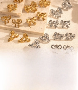 Detailed view of titanium steel bow earrings with vacuum plating in gold and silver finish