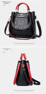Detail of black pebbled leather tote with red handles and gold kangaroo logo accents